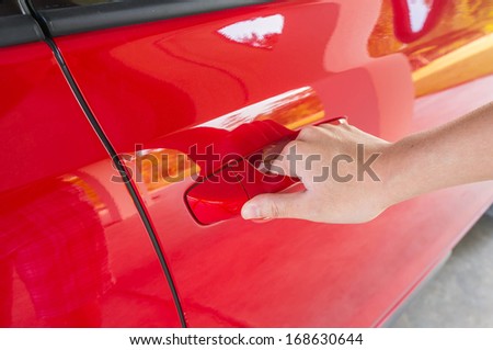 women\'s hand opening red painted car door