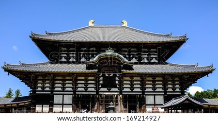 famous historic wooden temple named Todaijo temple in nara, japan, crowded with tourist and clear sky in background