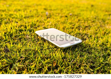 touch screen smart phone on the field of grass