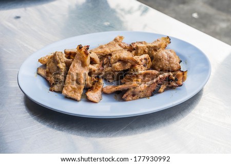 thai style grilled pork in plastic plate