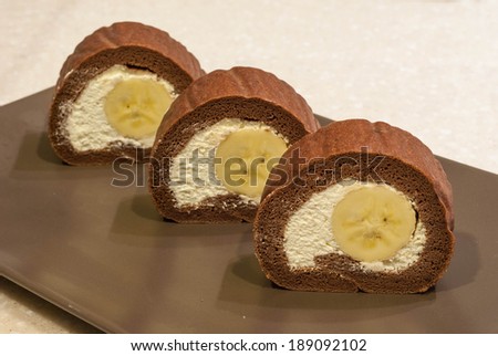 chocolate swiss roll cake with banana inside serve in plate