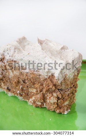 Cake with biscuits and chocolate on green triangle plate.