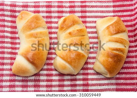 Baked rolls on the kitchen tablecloth.