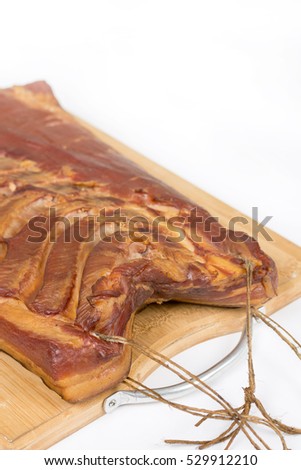 Whole piece of cured pork bacon on the wooden board