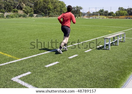 Green grass and sport lines painted at outdoor playing field with a man running