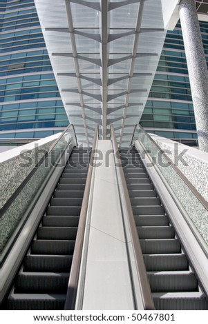 Detail of escalator stairs at a modern office building center - going up, going down