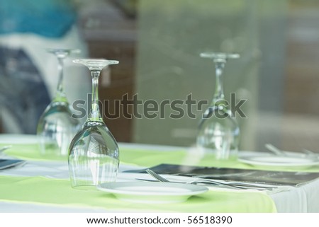 Table setting at a European restaurant. Glasses of wine set on dining table (Selective focus on front glass)