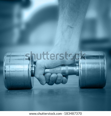 Hand of a man taking a dumbbell