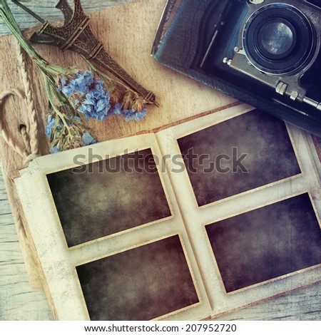 vintage camera and picture frame over wooden background