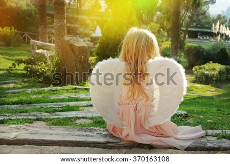 Beautiful young girl wearing angel wings