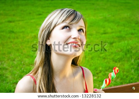 beautiful white woman with sugar candy dreaming or praying on a green grass