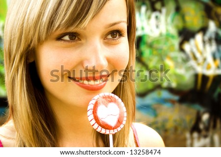 beautiful white woman with sugar candy thinking on a graffiti