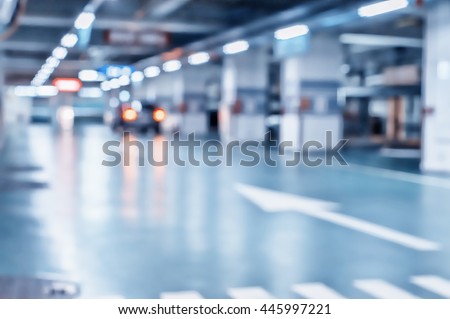 Blurred image/ Parking garage - interior shot of multi-story car park, underground parking with cars.