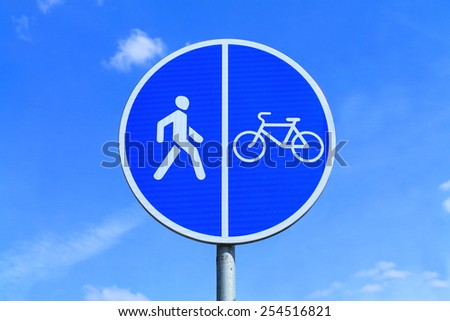 Road sign the Bicycle path and the Foot path, against the blue sky