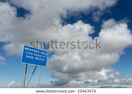 Approaching storm clouds next to Weather Info sign