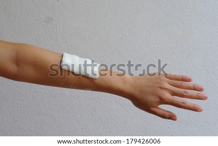 Close-up image of a white bandage wrapped on injured arm.