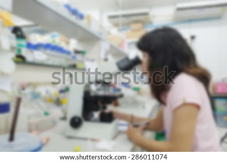 blurred image of research in laboratory. Scientist working with samples of DNA test into a test tube