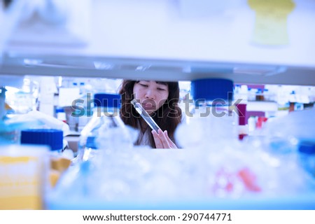 scientists with pipette and flask making test or research in clinical laboratory. or woman doctor looking at a test tube of clear solution in a laboratory,soft focus,blurred image