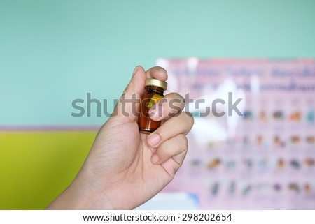Close up of a small glass bottle (pill/sirup bottle) in hand