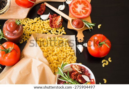 Ingredients. Pasta with Fresh tomatoes, Sun-dried tomatoes and Tomato Sauce on dark background. Cooking concept. Italian cuisine.