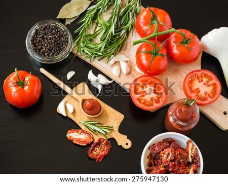 Ingredients. Fresh tomatoes, Sun-dried tomatoes, Tomato Sauce and Spices on dark background. Cooking concept. Healthy foods.