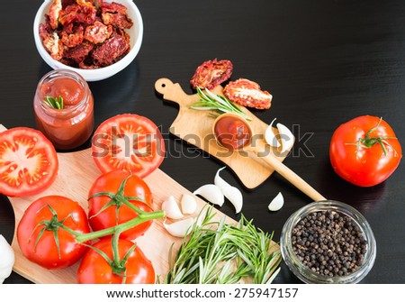 Ingredients. Fresh tomatoes, Sun-dried tomatoes, Tomato Sauce and Spices on dark background. Cooking concept. Healthy foods.