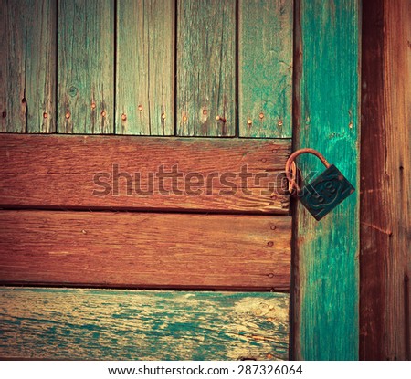 Old wooden door with a padlock. Vintage background. Image with retro instagram filter effect