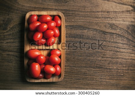 View from above of baby tomato on wood texture table