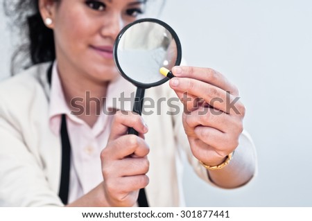 Business woman inspect medicine with magnifier