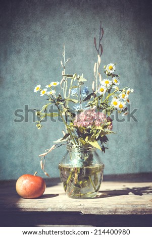 Stilllife with Apple and Bouquet of Wild Field Flowers on Wooden Table