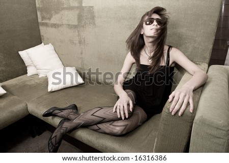 Young attractive female adult sitting on sofa and shaking head
