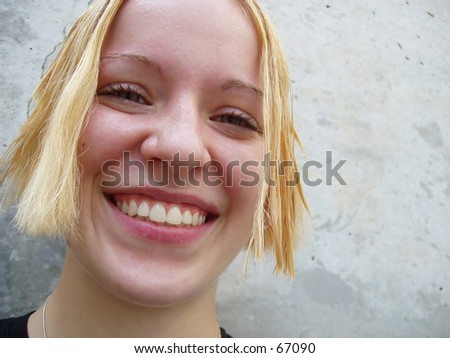 Very sharp shot of smiling blonde girl (with slightly wet hair & face)  looking directly into the camera - excellent detail.