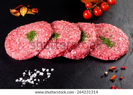 Meat. Raw meat. burger steak on black background with herbs and tomato
