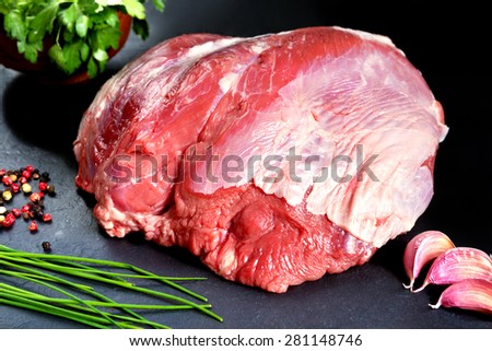 Fresh and raw meat. Whole piece of red meat ready to cook on the grill or BBQ .Background black blackboard