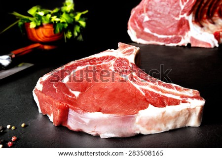 Fresh and raw meat. Ribeye. Uncooked steaks grilled BBQ on black background blackboard. Grilled meat and barbecue, steaks uncooked meat. BBQ