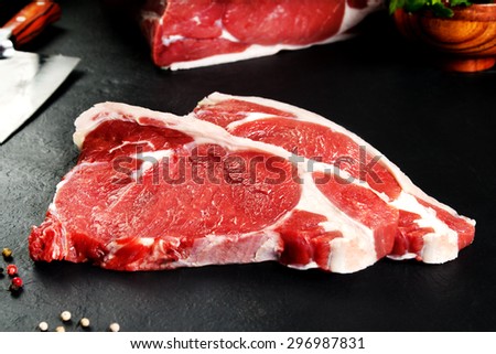 Fresh and raw meat. Ribeye. Uncooked steaks grilled BBQ on black background blackboard