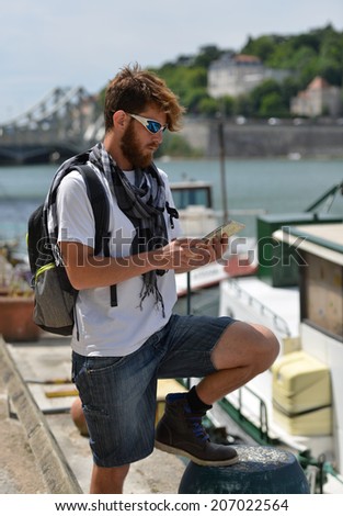young tourist man with backpack and city map