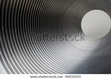 Metal tunnel of metal tube showing light at end of tunnel.