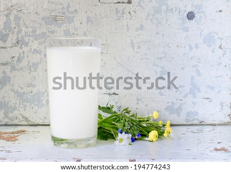 the glass of milk on old wooden background