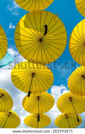 colorful yellow  umbrellas under the beautiful  cloudy sky. summer background