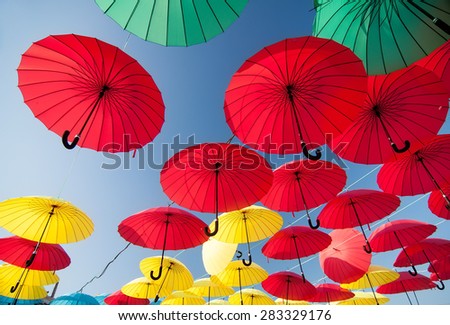 colorful yellow, red, blue and green  umbrellas under the beautiful cloudy sky