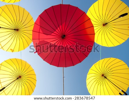 colorful yellow and red umbrellas under the beautiful cloudy sky