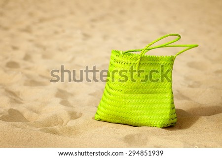 green bag on sandy beach. natural summer background