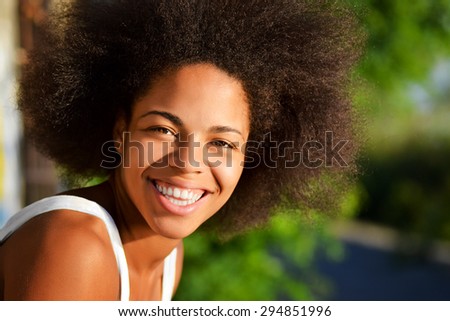 young happy and  pretty afro woman closeup portrait  on natural background