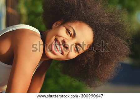 young happy and  pretty afro woman closeup portrait on natural background