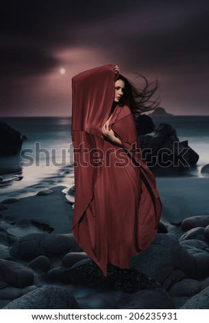 Beautiful Mysterious woman in long dress at ocean beach. Fantasy woman. Water Goddess. Book cover.