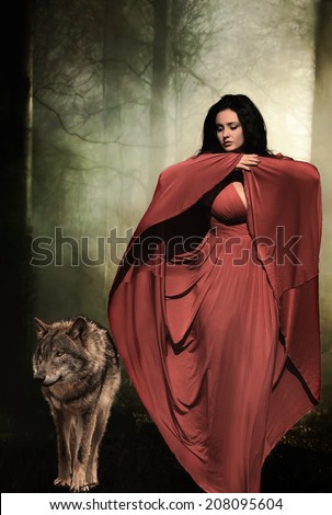Mysterious dark woman in forest at night with wolf. Book cover