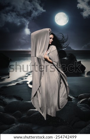 Beautiful Mysterious woman in long dress at ocean beach. Fantasy woman. Water Goddess. Book cover.