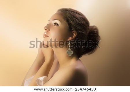 Beautiful young brunette woman with earring.