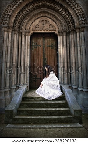 Beautiful young woman in white dress at church stairs